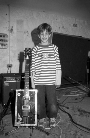 Tyrone Wood with Bo Diddley square guitar, Ronnie Wood home and Recording studio, Co Kildare, c 1996 (b/w photo)