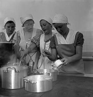 BdM girls learning how to cook at the kitchen of the school for home economics at Greifenberg, Germany 1930s (b/w photo)