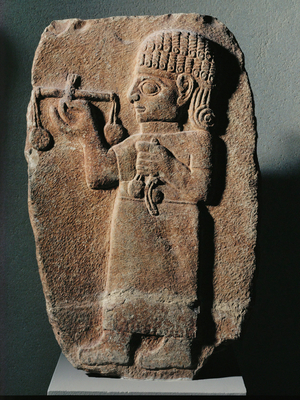 Merchant carrying a pair of scales for weighing metals …