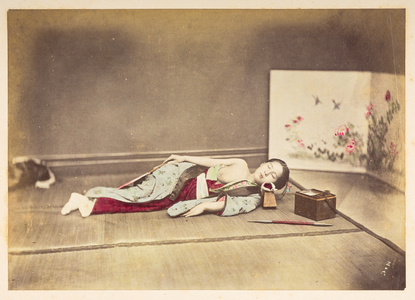 Japanese woman sleeping,  Studio portrait of a young Japanese woman sleeping, one breast exposed and with her head resting on a wooden pillow, Photographer: Unknown Lucas Collection: Photographic record of the world tour of Charles James and Morton P,  Lucas, 1877-79, Dimensions: 143 mm x 202 mm