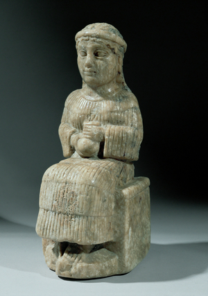 Sitting woman holding a small vase …
