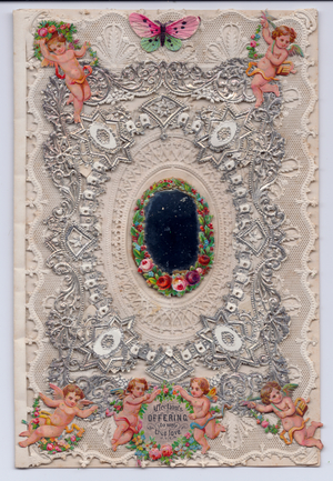 A Victorian silver embossed paper lace greeting card of a mirror surrounded by a wreath of flowers and paper scraps of cupids, c.1880 (colour litho)