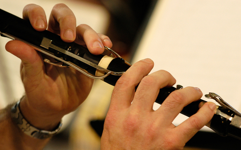 Flute and flautist's hands, close-up.