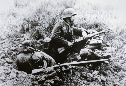 German NCO in a foxhole armed with the short Kar 98k carbine, K98b Mauser rifle nearby, France, 1940 (b/w photo)