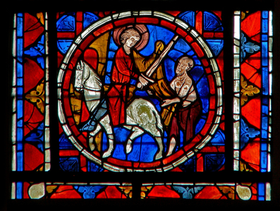 Window w109 depicting the Charity of St Martin: he divides his cloak (stained glass)
