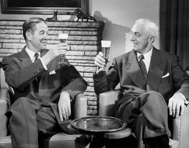Two mature men toasting with beer glasses