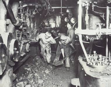 Stokers shovelling coal in boiler room of ship, 1918 (b/w photo) 