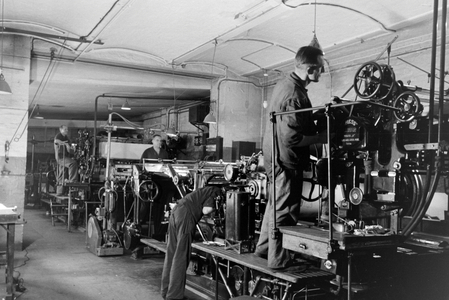 Printery workers working on the rotary printing press in the plants of the mechanical engineering company MAN (Maschinenfabrik Augsburg-Nürnberg), Germany 1930s (b/w photo)