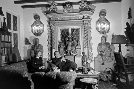 German actor Paul Wegener smoking a cigar while sitting in his living room with his wife, actress Greta Schroeder, at his house in Berlin, Germany 1930s (b/w photo)