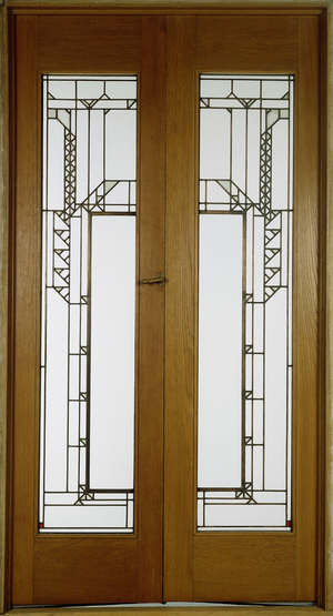 A pair of glass doors, of slender elongated form with stylized abstract foliate motifs against a clear ground, 1912 (leaded glass within wooden frames)