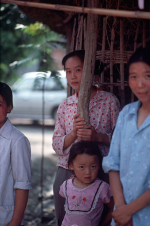 Young Chinese woman with her family in Sichuan Province village, China (photo)