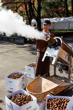 Japan, Honshu, Tokyo, Hibiya Park, Food Festival, Man Making Roasted Chestnuts in Traditional Steamer (photo)