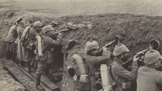 German soldiers in the trenches in Flanders firing through loopholes made from small wooden boxes and sewer pipes (b/w photo)