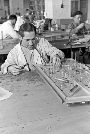 A staff member producing a fluorescent tube, Germany 1930s (b/w photo)