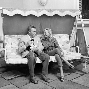 German actor and presenter Peter Frankenfeld with his wife Lonny Kellner on a porch swing, Germany 1960s