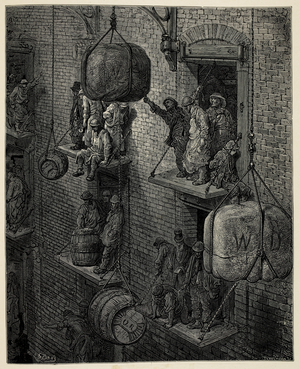 Barrels and large loads being hoisted outside of a warehouse.