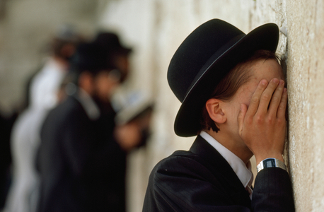 A young ultra-Orthodox Jew covers his face, prays at the wall. Wailing Wall, Old..., 1980s (photo)