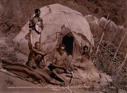 Group of Zulus in Front of Hut, Elder Zulu Cutting Knobkerrie, Africa, c. 1890