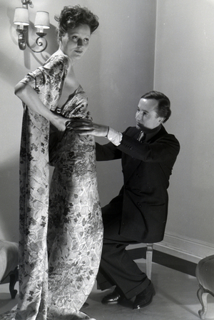 The fashion designer Heinz Schulze-Bibernell and a model trying a dress, Germany ca.1939 (b/w photo)