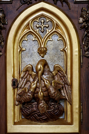 Tabernacle door. Mother pelican feeding her little baby pelicans symbolise the Passion of Jesus and the Eucharist. France.