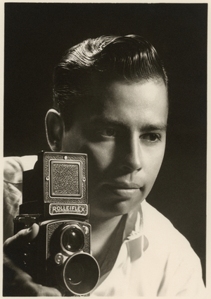 Orlando Suero portrait with Rolleiflex camera, c.1954 (b/w photo)