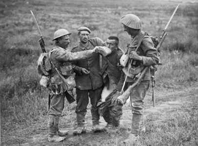 British soldiers offering water to German prisoners, 1914-18 (b/w photo)