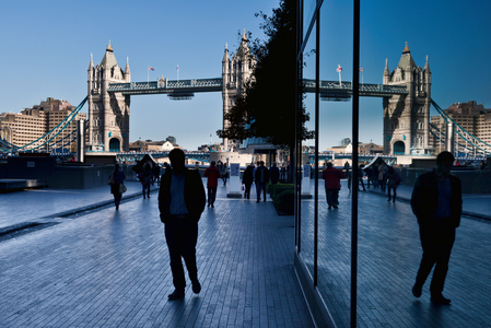 Pedestrians on a walkway with London's tower bridge in the background, London, England, UK  (photo)