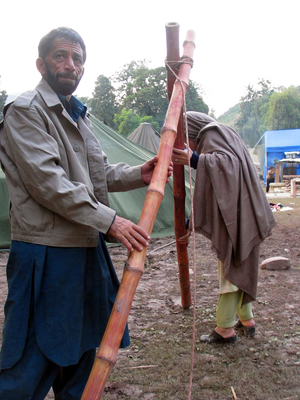 Pakistani victims try to set up a temporary tent in quake-shattered Muzaffarbad, capital city of Pakistan-controlled Kashmir, on Oct 18, 2005