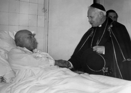cardinal Suhard visiting social centers of the 12th arrondissement in Paris, here shaking hands with a sick man at the Red CRoss hospital february 12, 1942 , Paris under german Occupation
