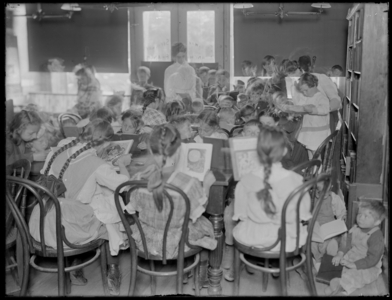 Children reading in the reading room of an unidentified branch of the Queens Borough Public Library, c.1910. (b/w photo)