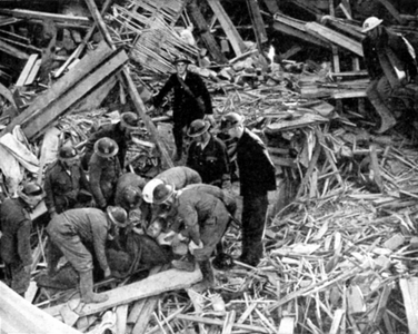 Rescue workers releasing injured person from the debris of a building destroyed by German bombing: 1940. World War II.