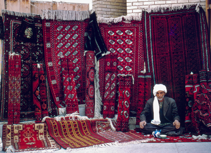 Persian carpet merchant with his rugs displayed on a sidewalk in Tehran, 1960., 1960 (photo)