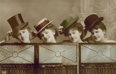Four young women wearing men's hats behind a screen (coloured photo)