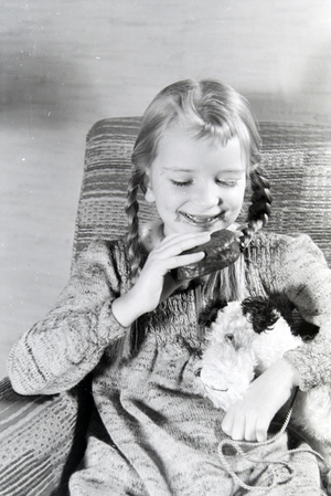 A girl eating Liegnitzer Bomben, Germany 1930s (b/w photo)
