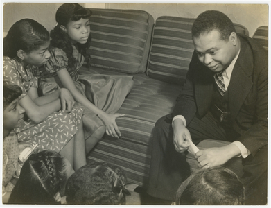 Countee Cullen reading to group of children, 1940s (b/w photo)