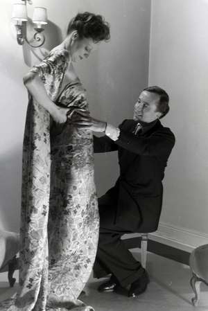 The fashion designer Heinz Schulze-Bibernell and a model trying a dress, Germany ca.1939 (b/w photo)