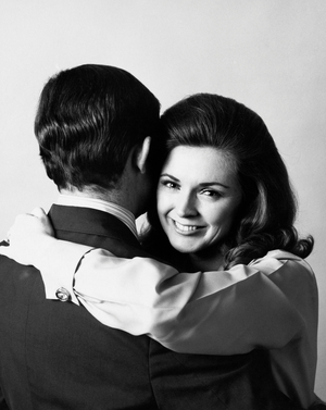 Portrait of a young woman embracing a young man