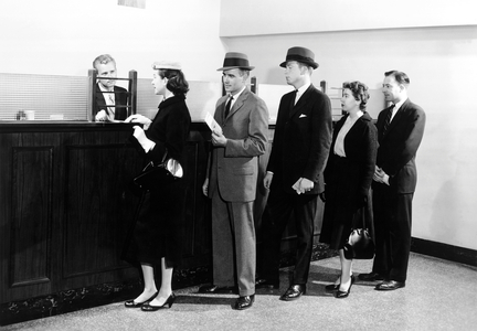 People waiting in line at bank (b/w photo)