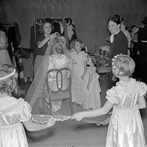 Childen and the bride being prepared for the part of the bridal wear part of the ADEFA fashin, show, Germany 1930s (b/w photo)