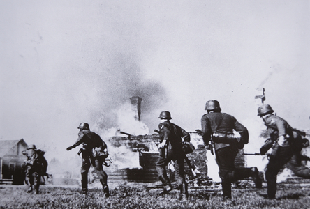 German infantry moving at the double througha burning Russian village during the invasion of the Soviet Unino, 1941 (b/w photo)