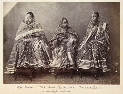 Bibi Doolan, Shah Jehan Begum and Secunder Begum in marriage costume [Bhopal]. A full-length seated portrait of (l. to r.) Dibi Doolan, Shah Jahan Begum and her mother Sikandar Begum, Regent of Bhopal, dressed in richly-decorated saris