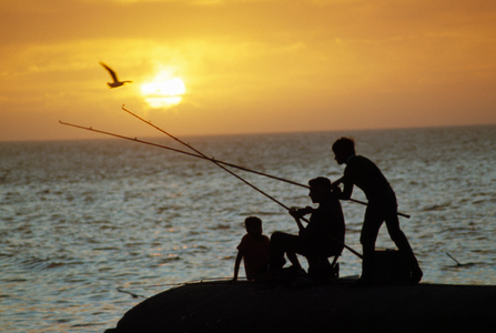 Silhouetted people fish from the shoreline near Montevideo. MONTEVIDEO, URUGUAY., 1960s (photo)