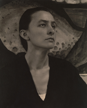 Georgia O’Keeffe in front of her charcoal drawing of Palo Duro Canyon No. 15 Special, 1918 (platinum-palladium print)