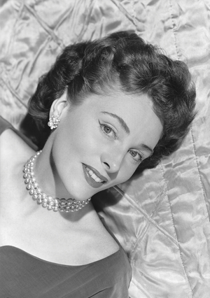 Portrait of young woman lying on bed, studio shot