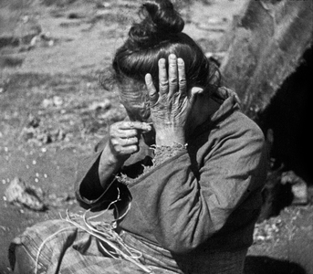 Inuit woman making yarn with tendons of a seal, Angmassalik, Greenland, Summer, 1936 (b/w photo)