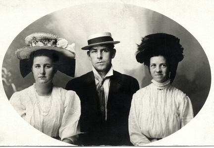 Two women Flanking Man, All in Hats, Portrait, c.1909