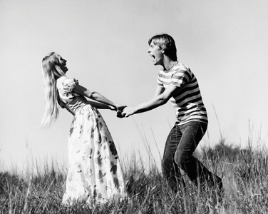Young couple holding hands in a field