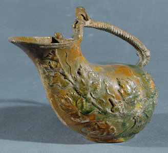 Askos with green glaze, decorated with vine branches …