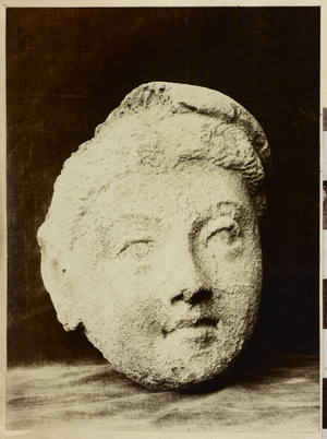 Taxila, Chir Tope [Dharmarajika Stupa]. Terracotta head (CH 589). Photographer: Archaeological Survey of India, 1914-15 (b/w photo)