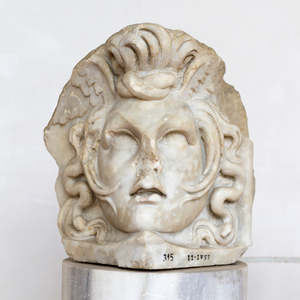 Acroterium corner stone representing Medusa's head, belonging to a sarcophagus, 170-190 AD, Luni marble, National Roman Museum at the Baths of Diocletian, Rome, Italy